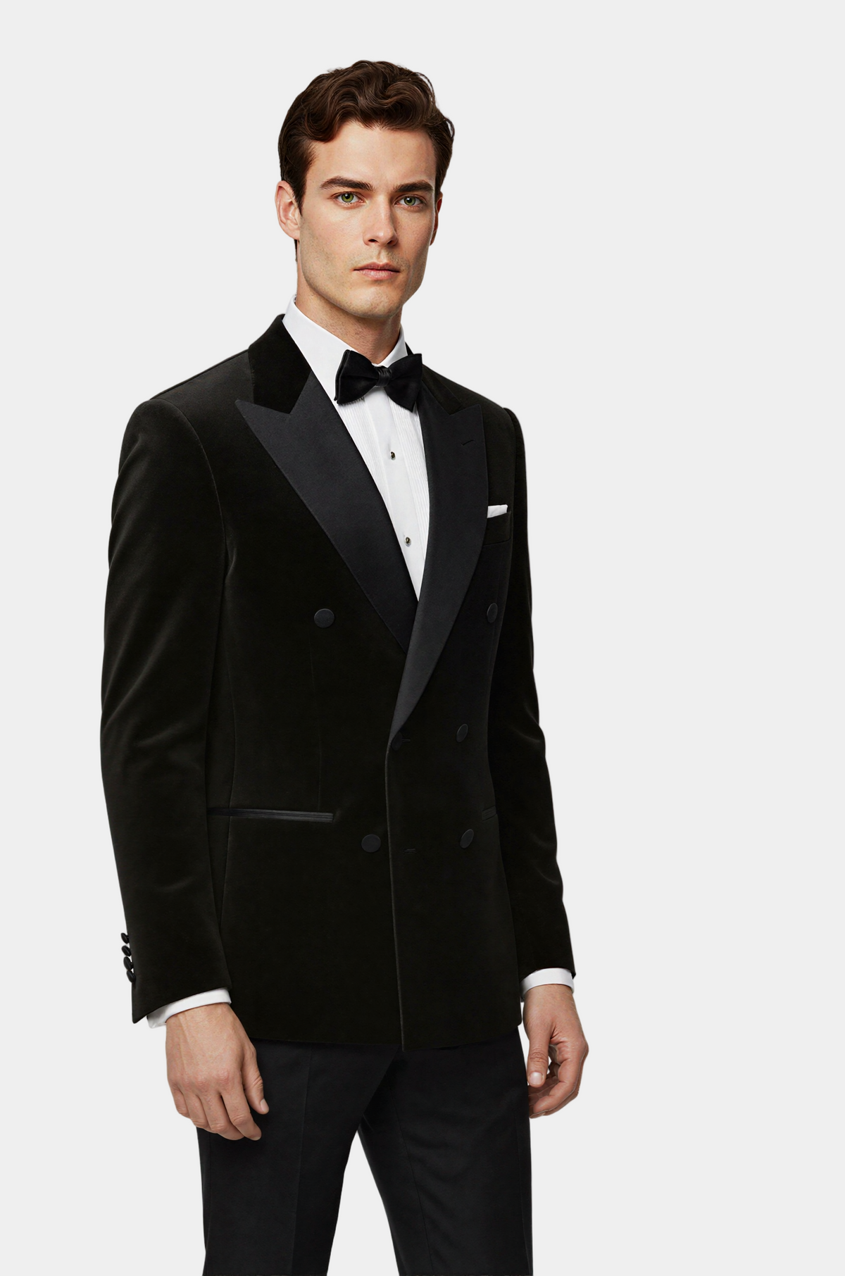 Man wearing a black tuxedo with a white shirt and black bow tie on a light gray background